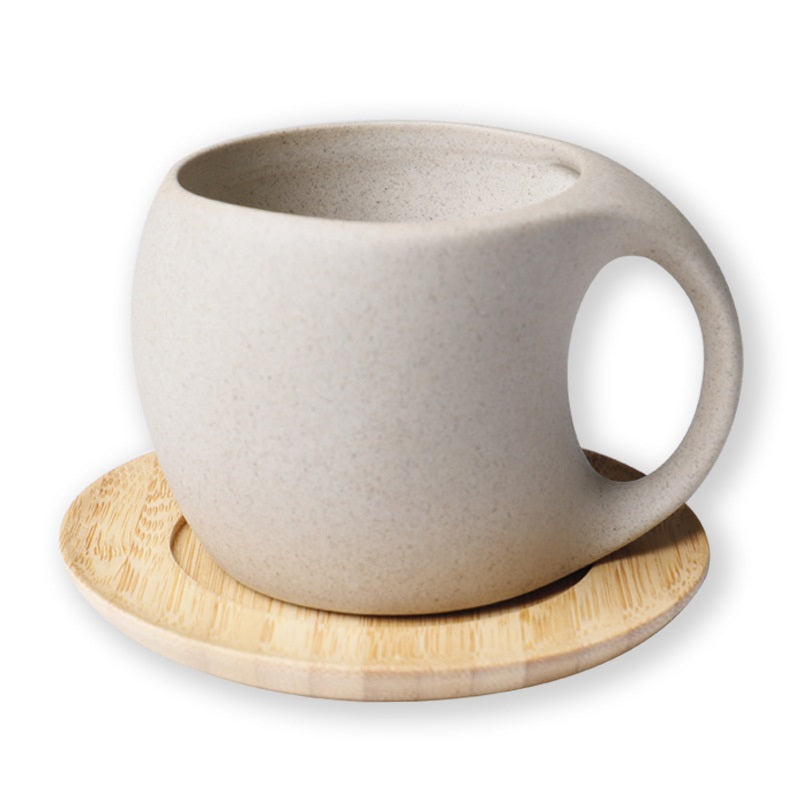 Round ceramic coffee cup with bamboo saucer on white background side view
