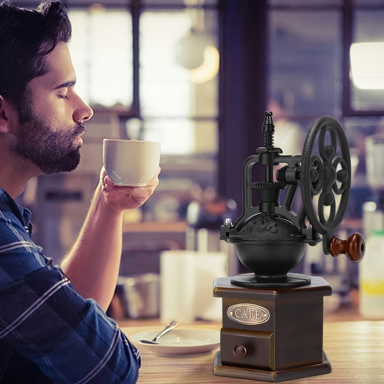 Man enjoying coffee with vintage manual cast iron wheel coffee grinder on cafe table