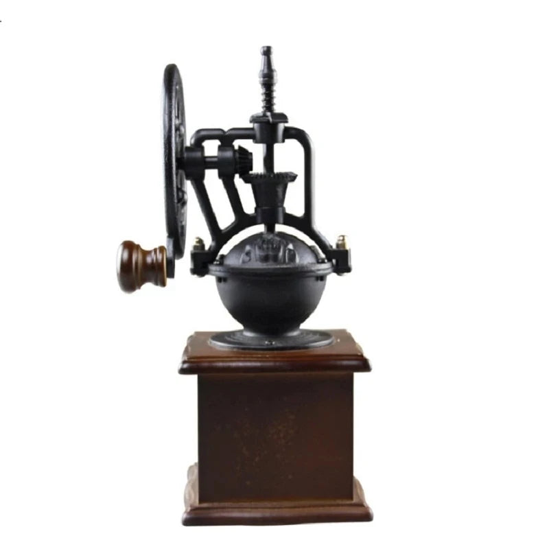 Rear view of vintage manual coffee grinder showing cast-iron wheel mechanism and wooden base on white background