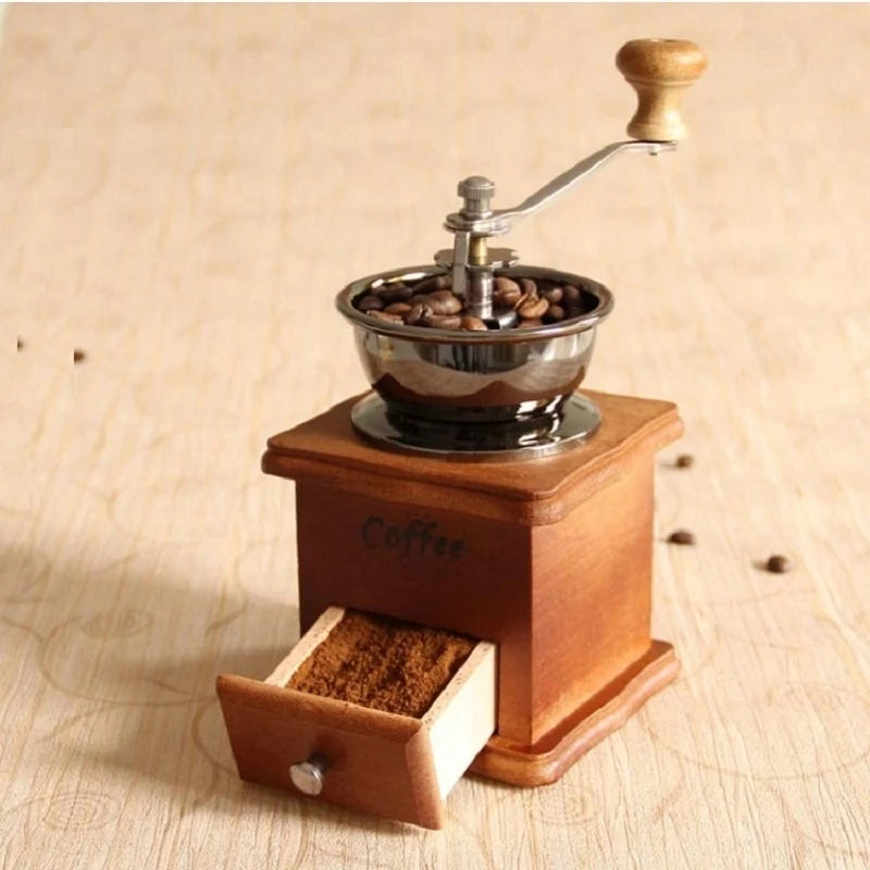 Wooden coffee grinder with a drawer for ground coffee on a wooden surface