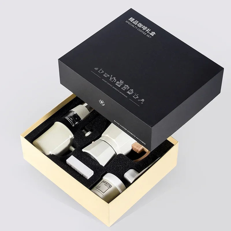 Open black and beige gift box containing white ceramic items on a light gray background