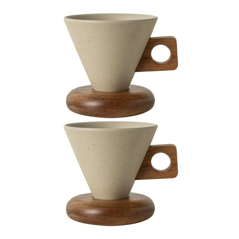 Two conical ceramic coffee mugs with wooden handles on round wooden saucers stacked vertically, white background