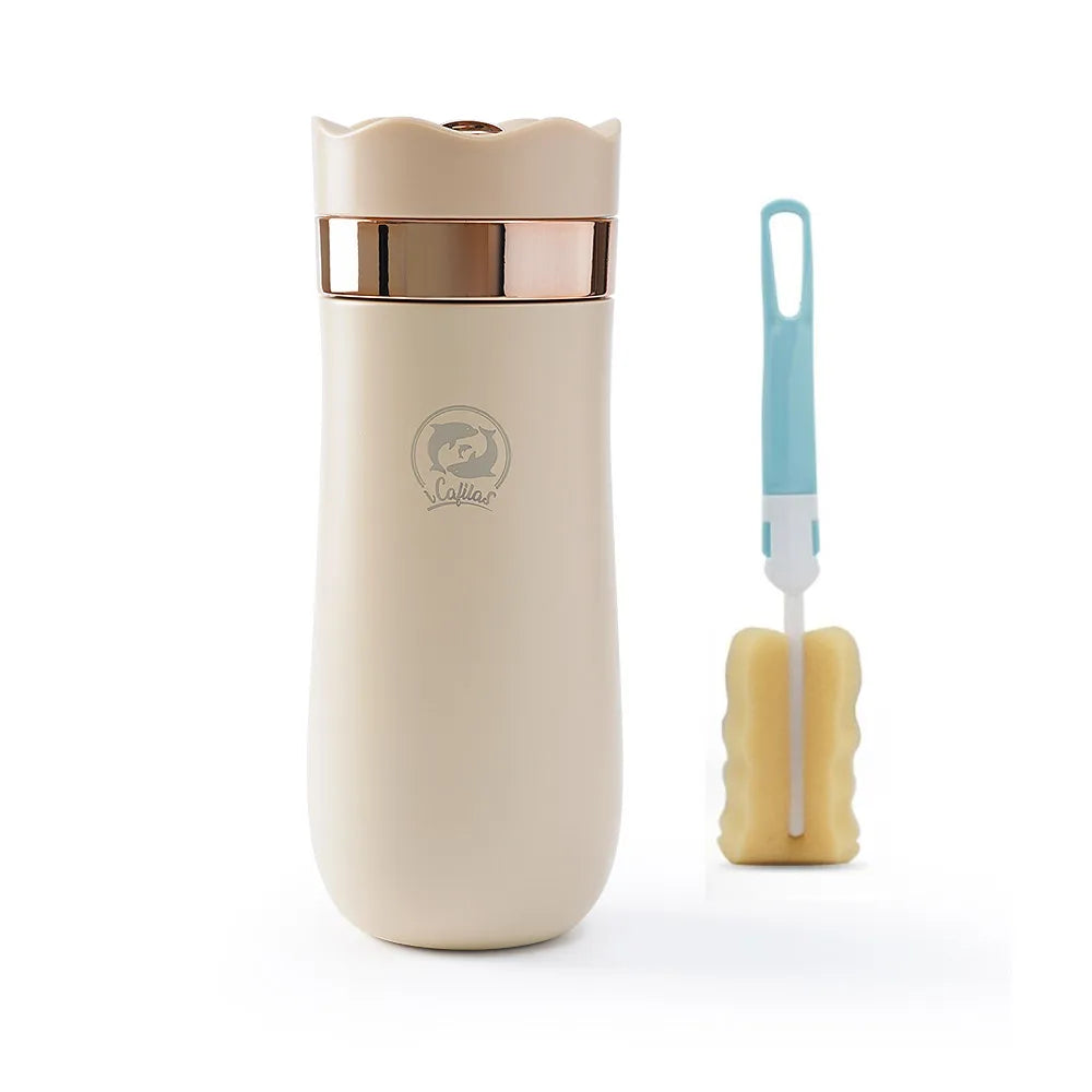 Beige travel french press mug with rose gold lid and cleaning brush on a white background