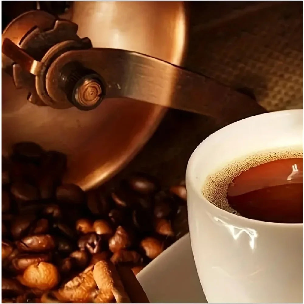 Close-up of a coffee grinder and cup with coffee beans, emphasizing the coffee-making process.
