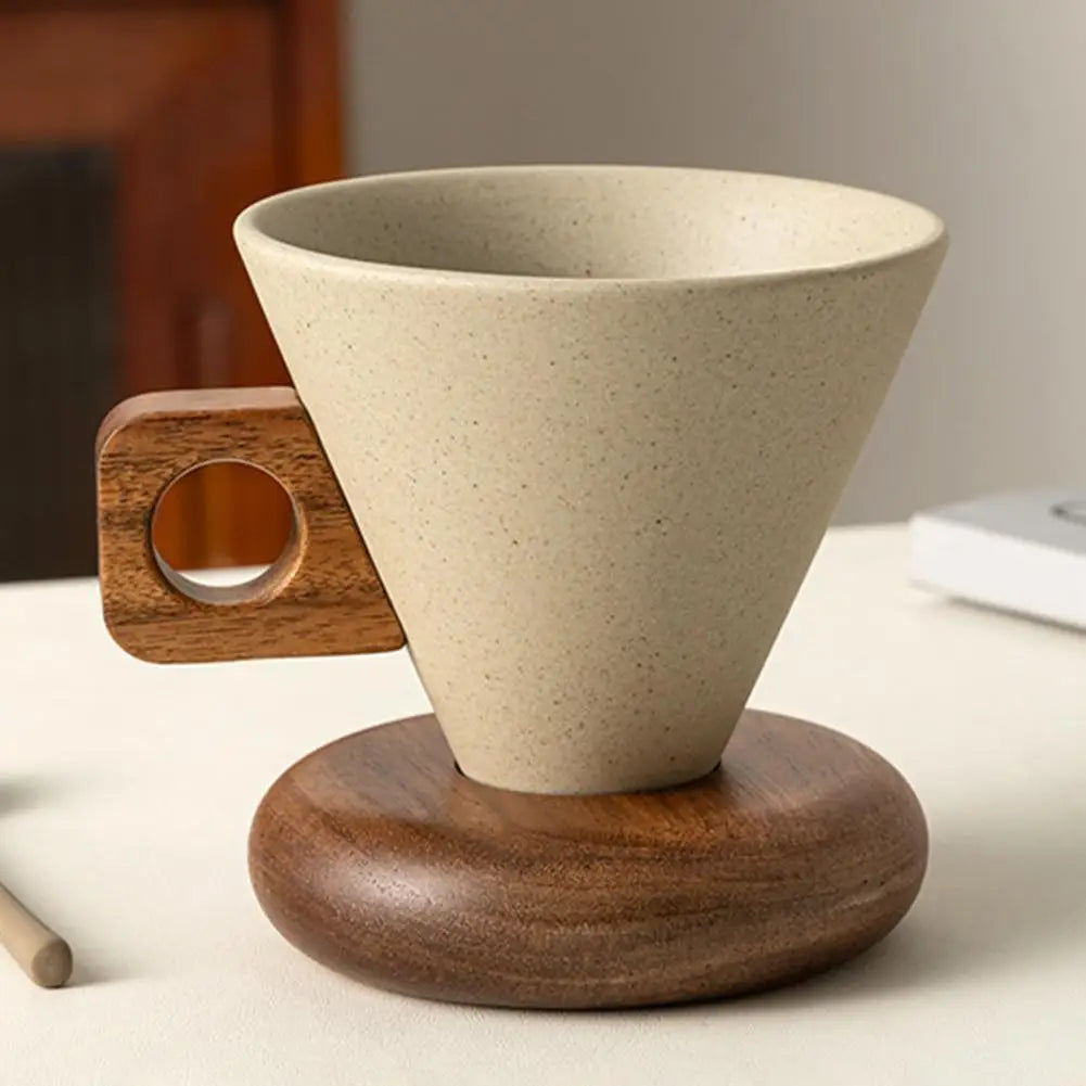 Close-up of a conical ceramic mug with square wooden handle resting on a round wooden saucer