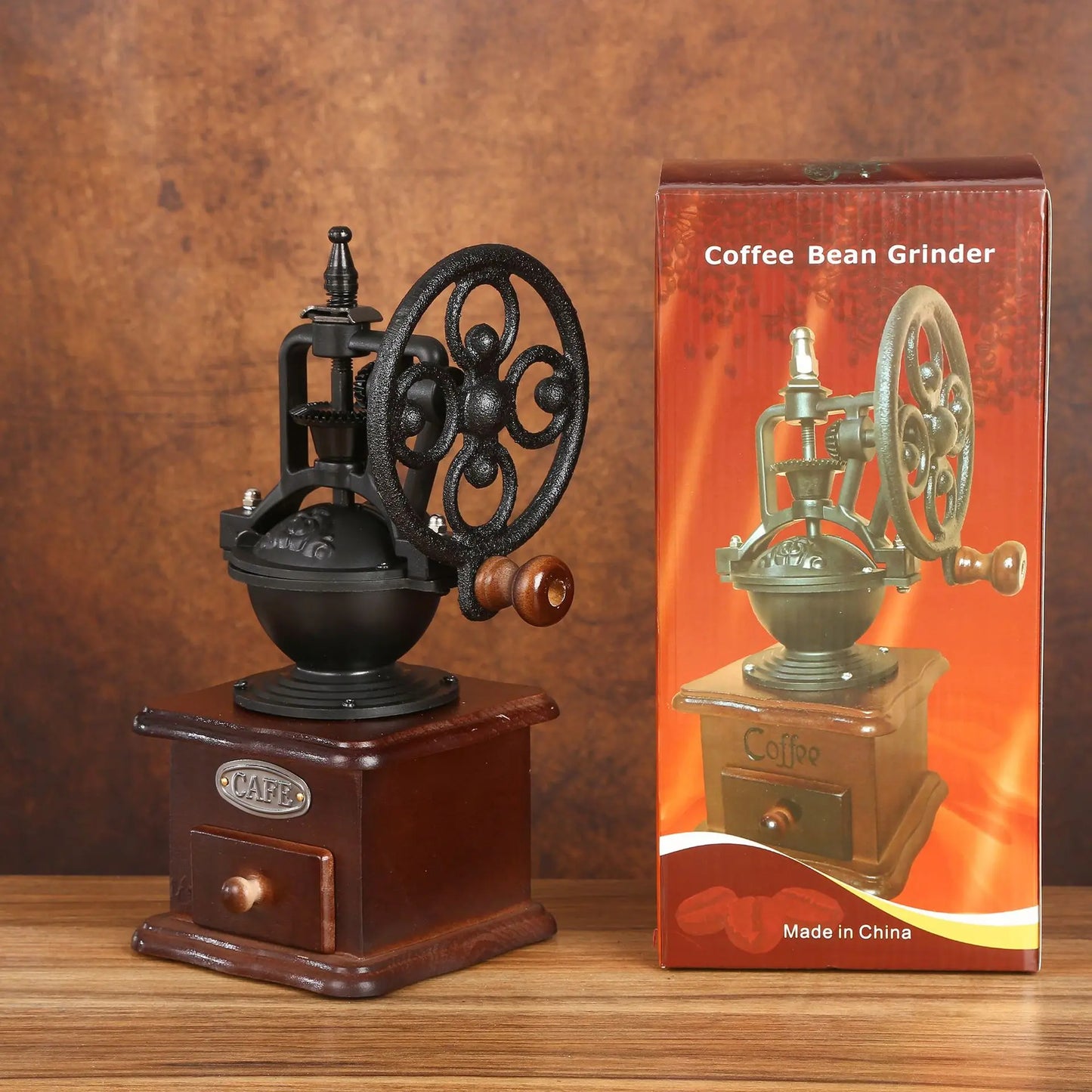 Vintage-style coffee bean grinder on a wooden surface with its packaging.